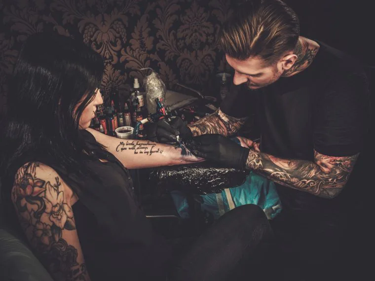 Artist tatuator în timpul lucrului